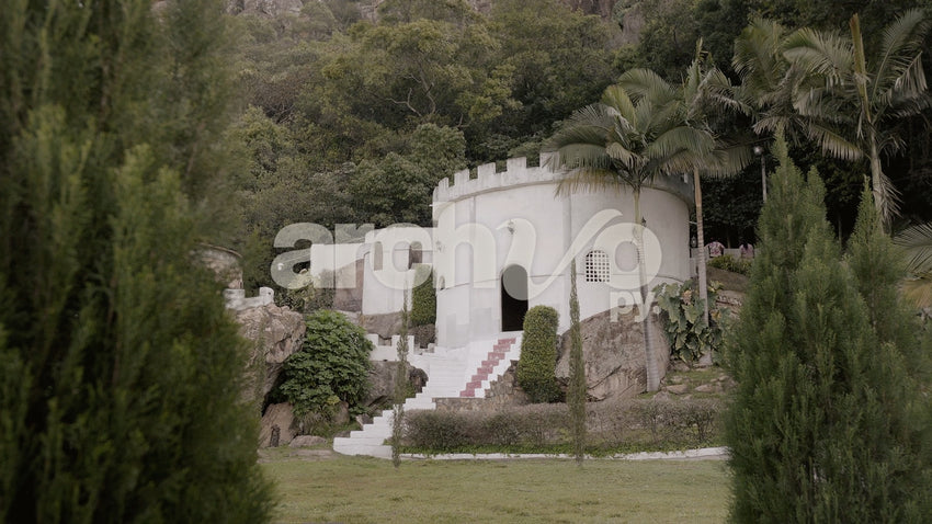 Castillo blanco rodeado de árboles y piedras