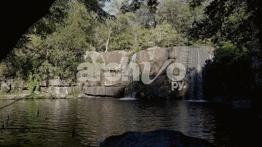 Cascada entre bosque y rocas en Concepción, plano fijo