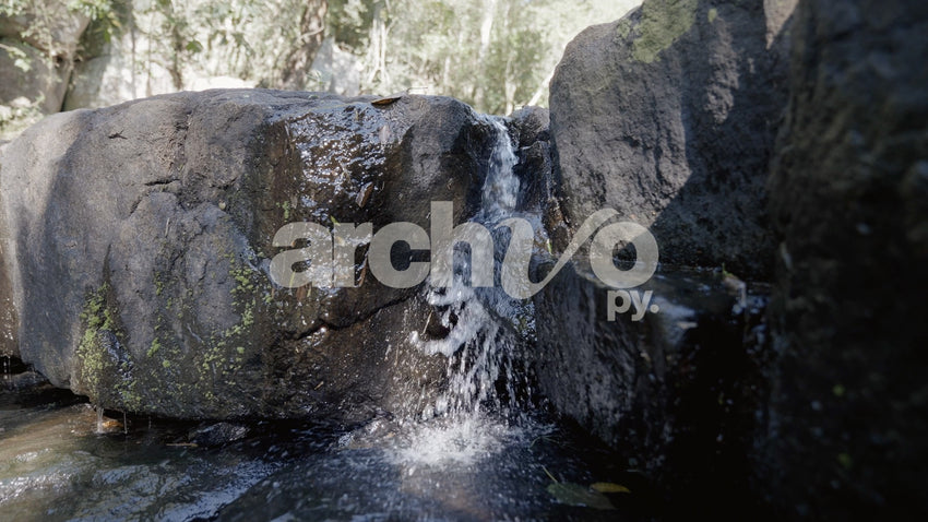 Agua de arroyo fluyendo entre rocas en Concepción, plano fijo