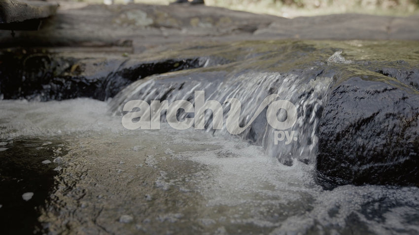 Agua fluyendo en salto sobre rocas en Concepción, plano fijo